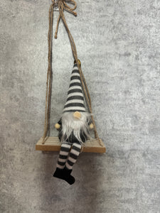 Grey Gonks sitting on a swing